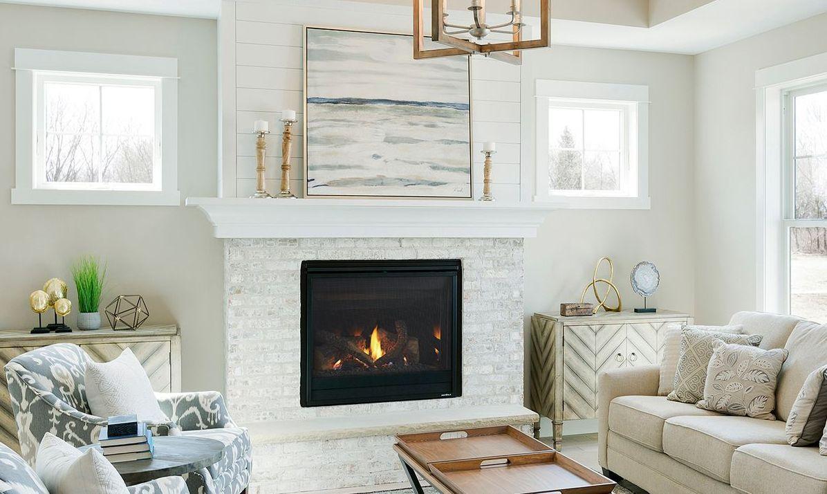 Gas fireplace in a white brick surround in a bright living room